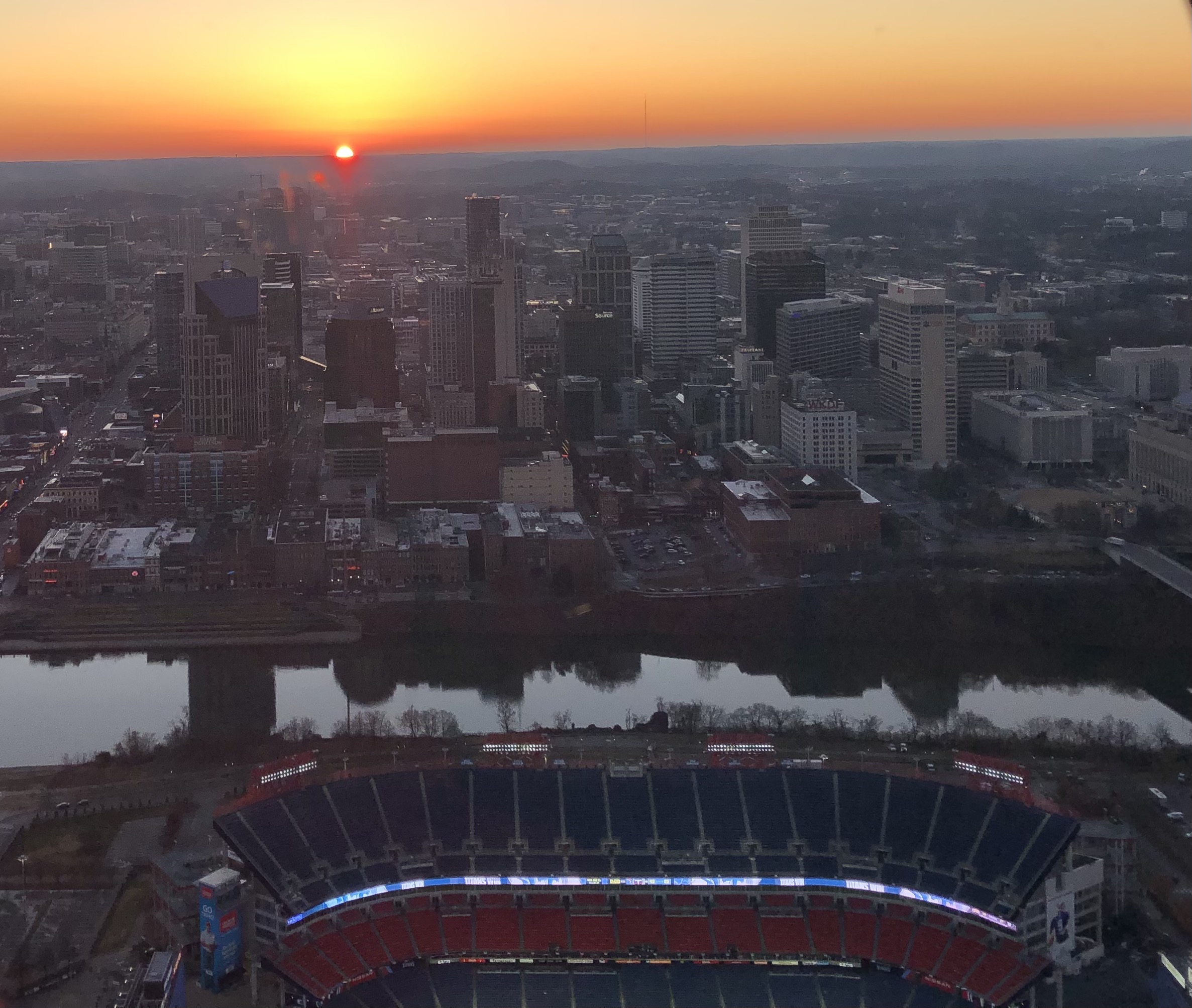 a sunset over a body of water with a city in the background